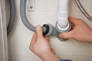 Дренажные трубы подсоединены к задней части стиральной машины и канализационной системе.