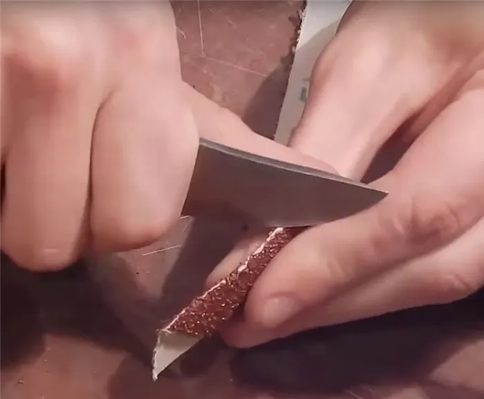 Соскребите ножом часть абразива с боковых сторон пленки.